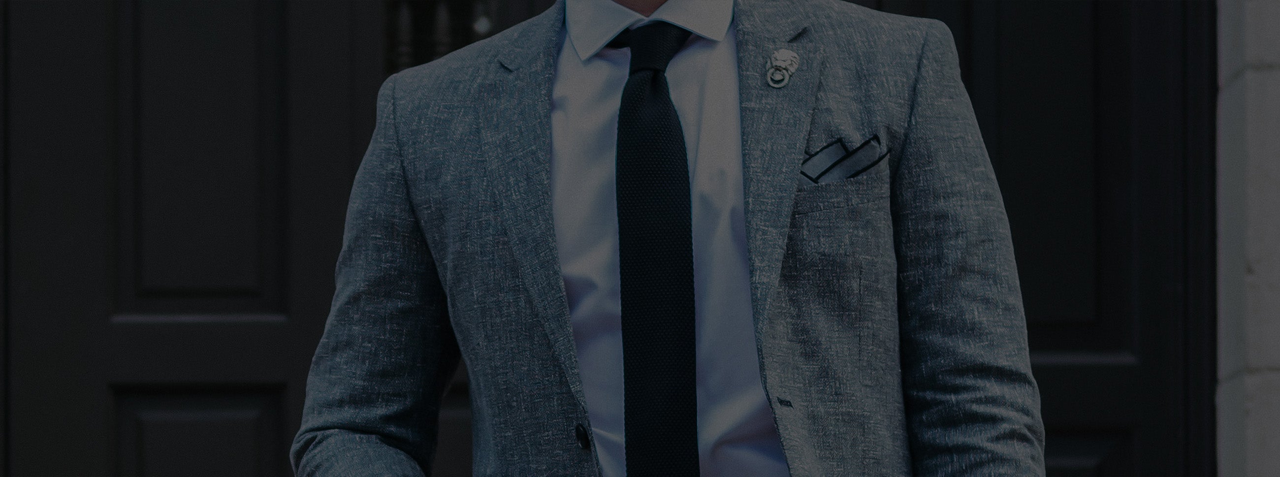 Man in grey suit with a knit tie