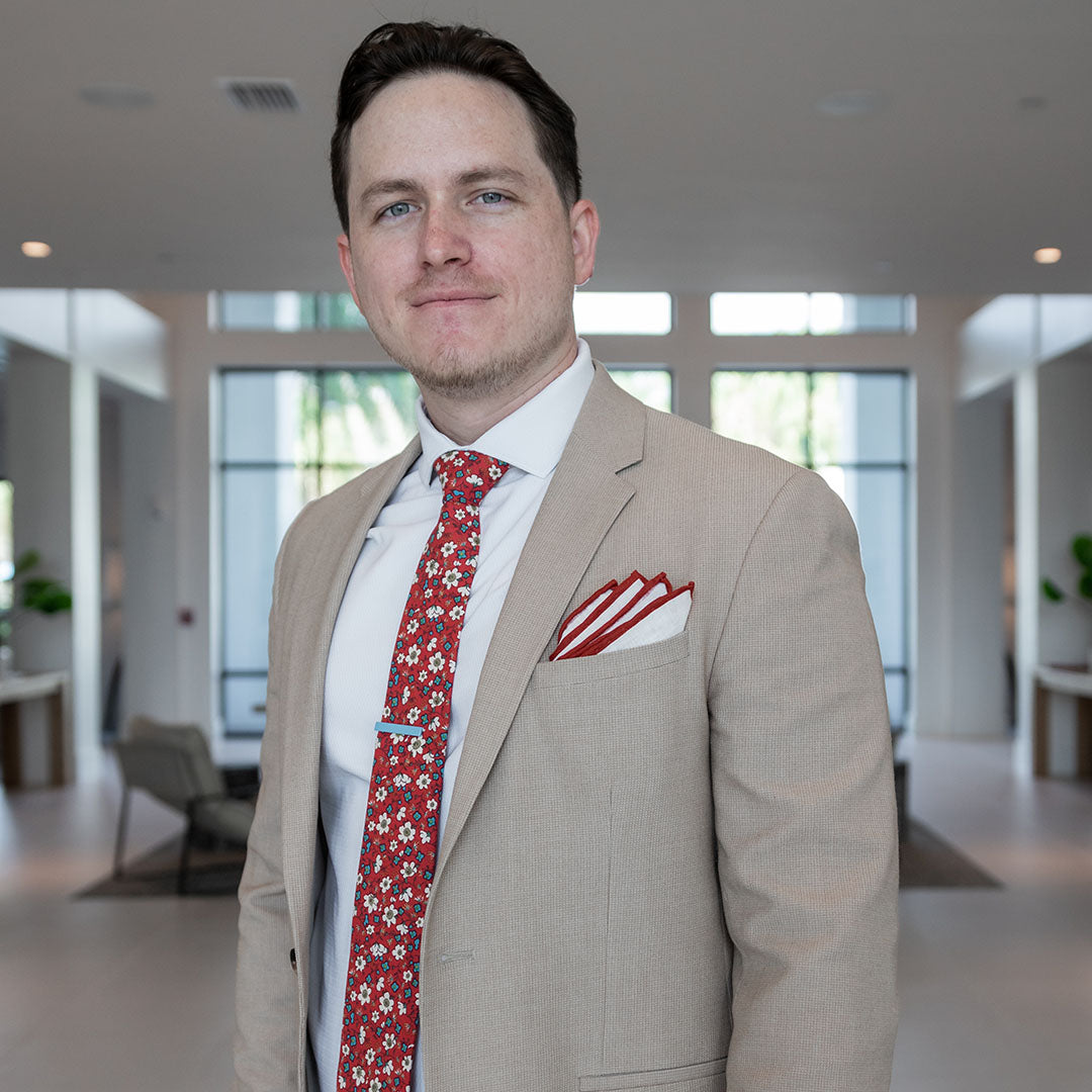 Floral red border pocket square in a tan suit pocket