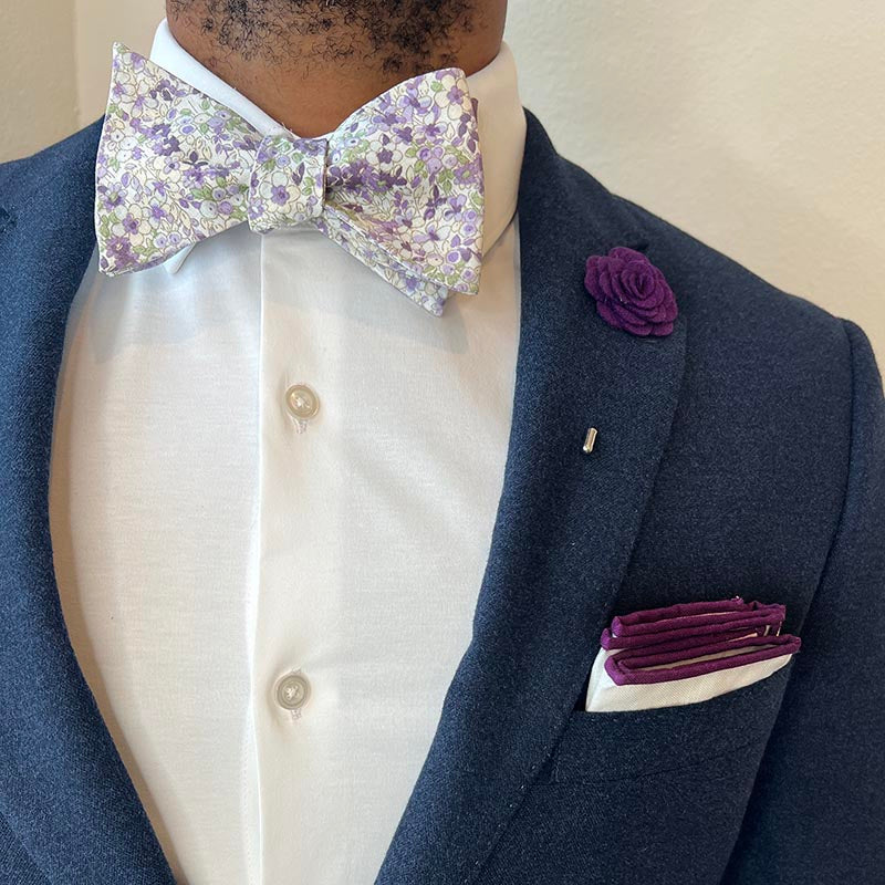 Man wearing a navy suit with Floral Tahiti Lavender Bow Tie Set and a white shirt