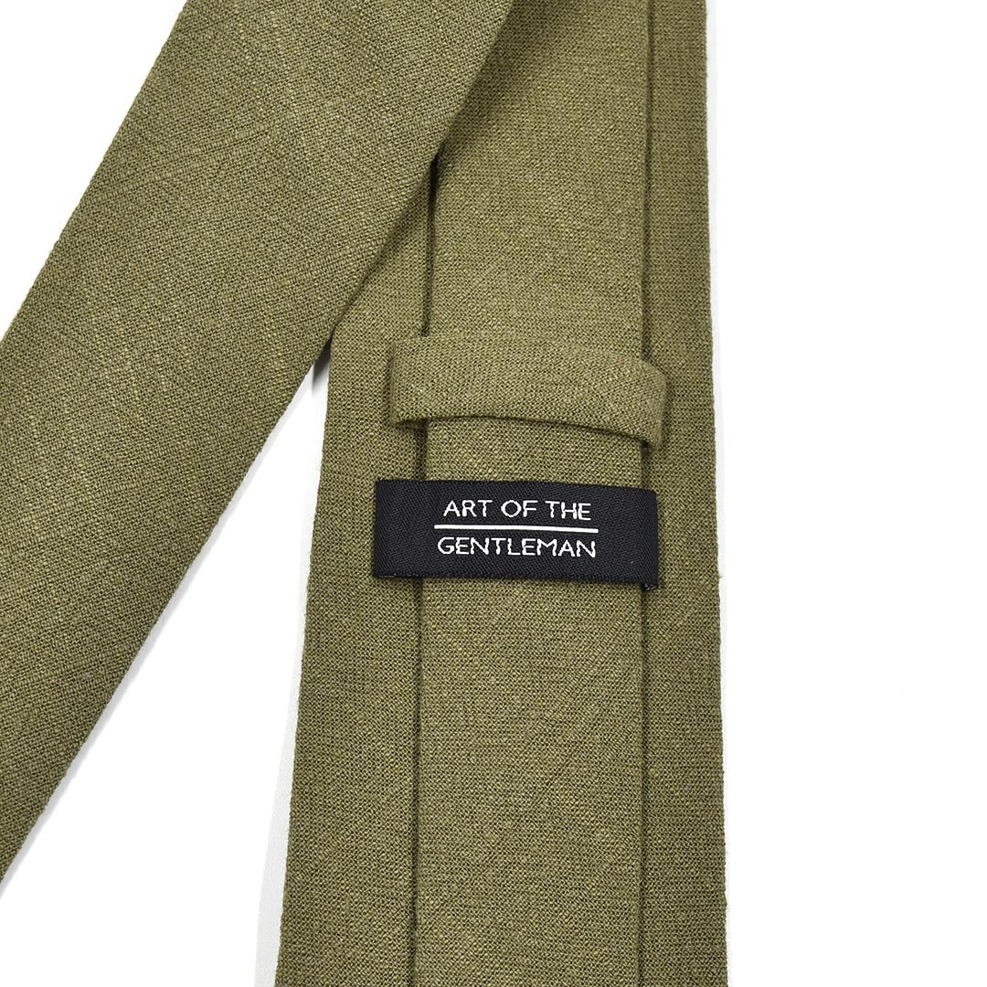 Green tie with 'Art of the Gentleman' label on a white background