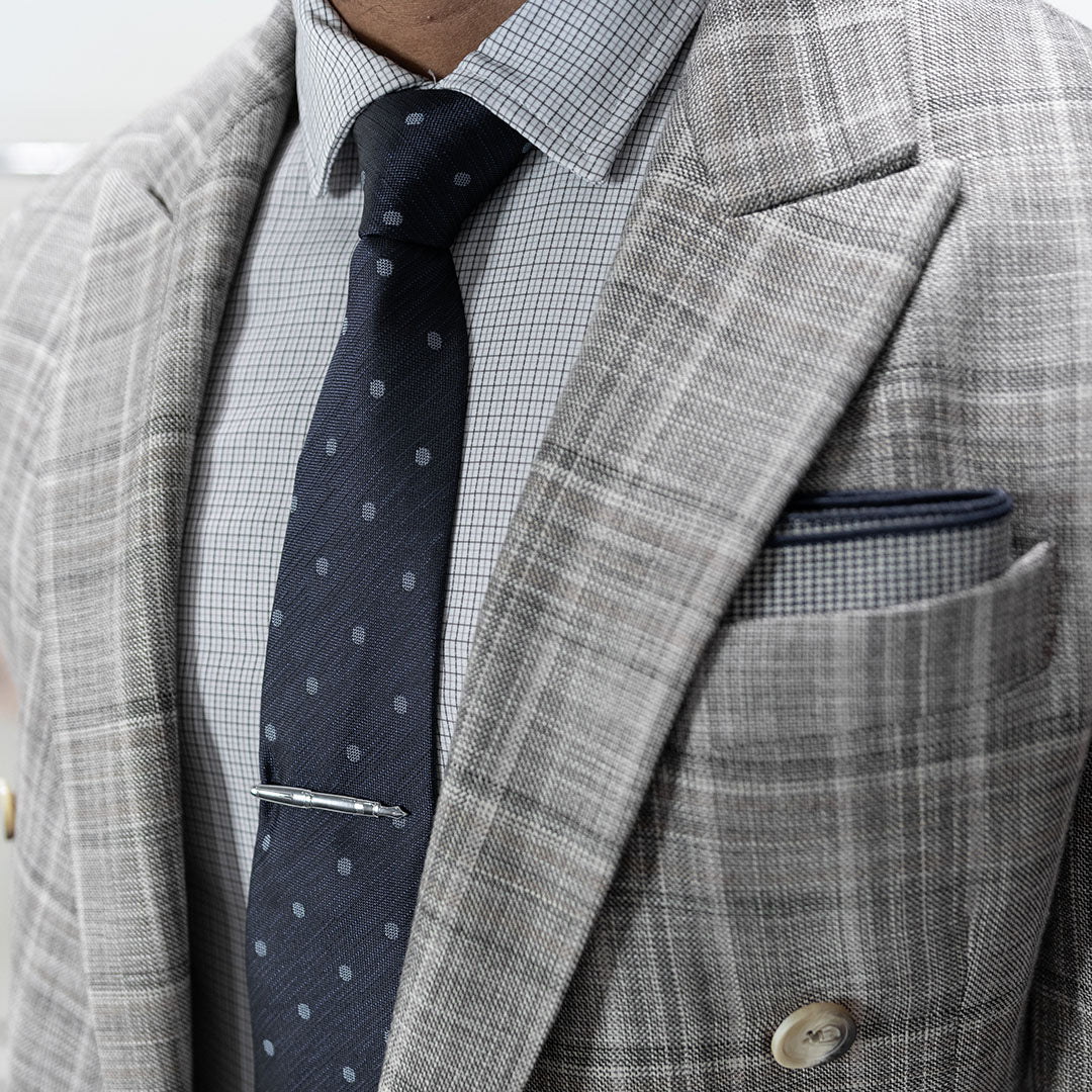 Gray checkered suit jacket with a blue polka dot tie and white shirt.