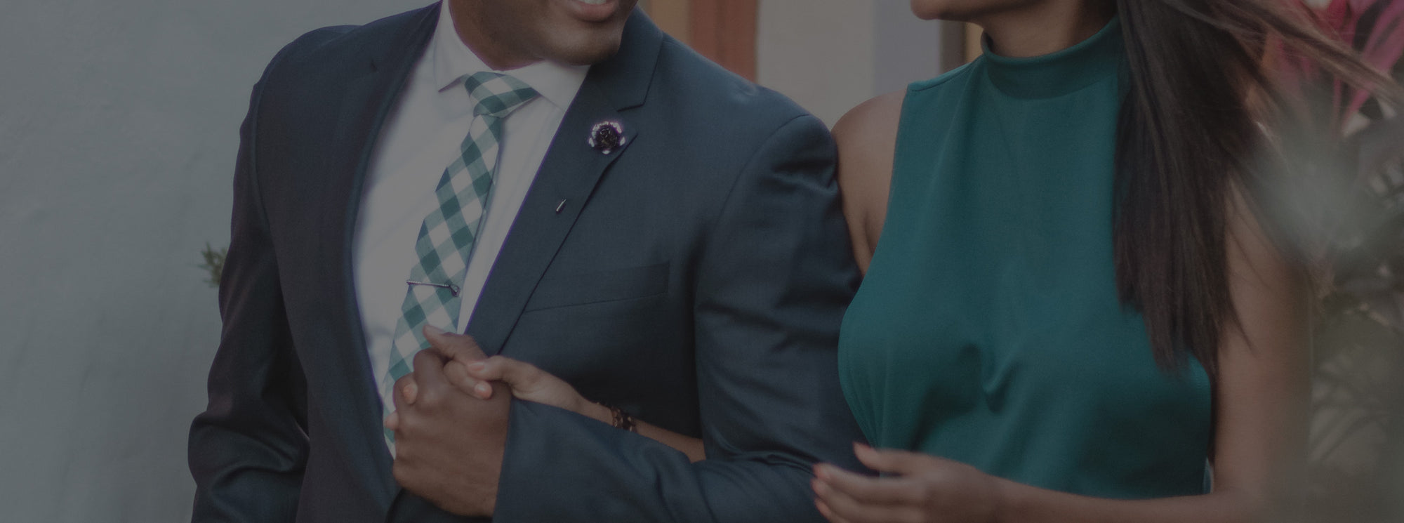 Man and woman holding hands dressed in a suit and tie