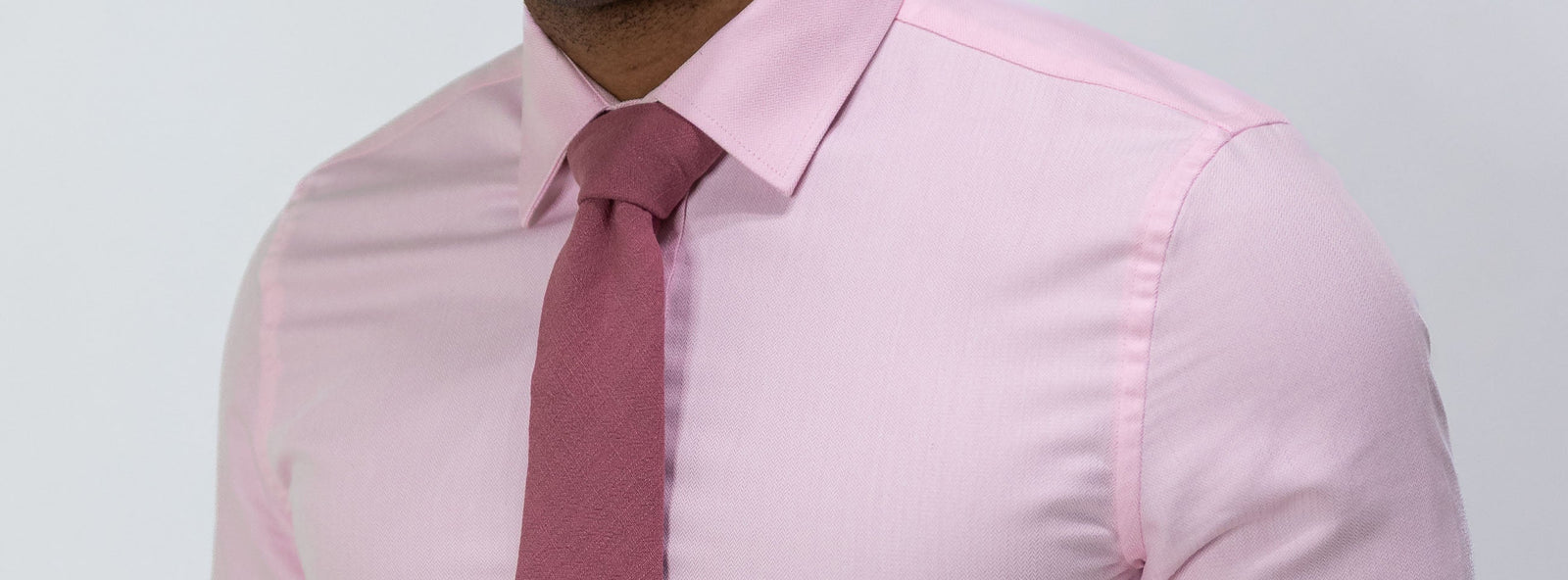 Man wearing a pink dress shirt with a dark pink complementing tie