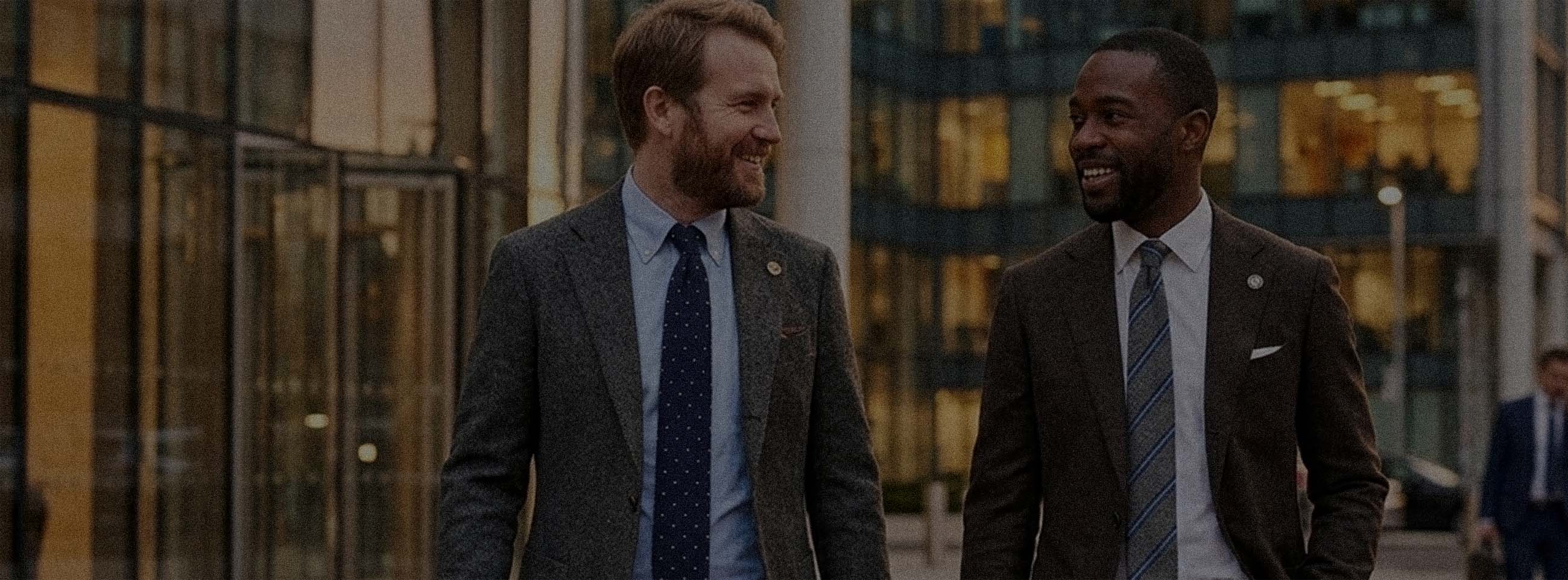 Two men in a city setting wearing suits and Knit Ties