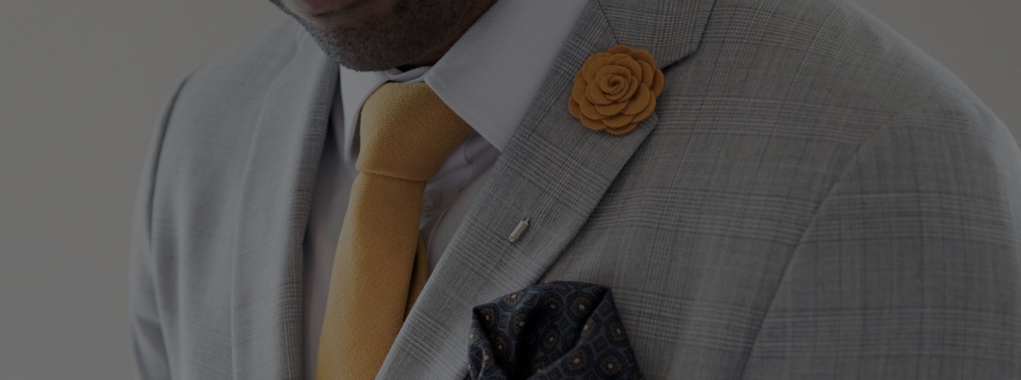 Light Grey suit with a yellow lapel pin