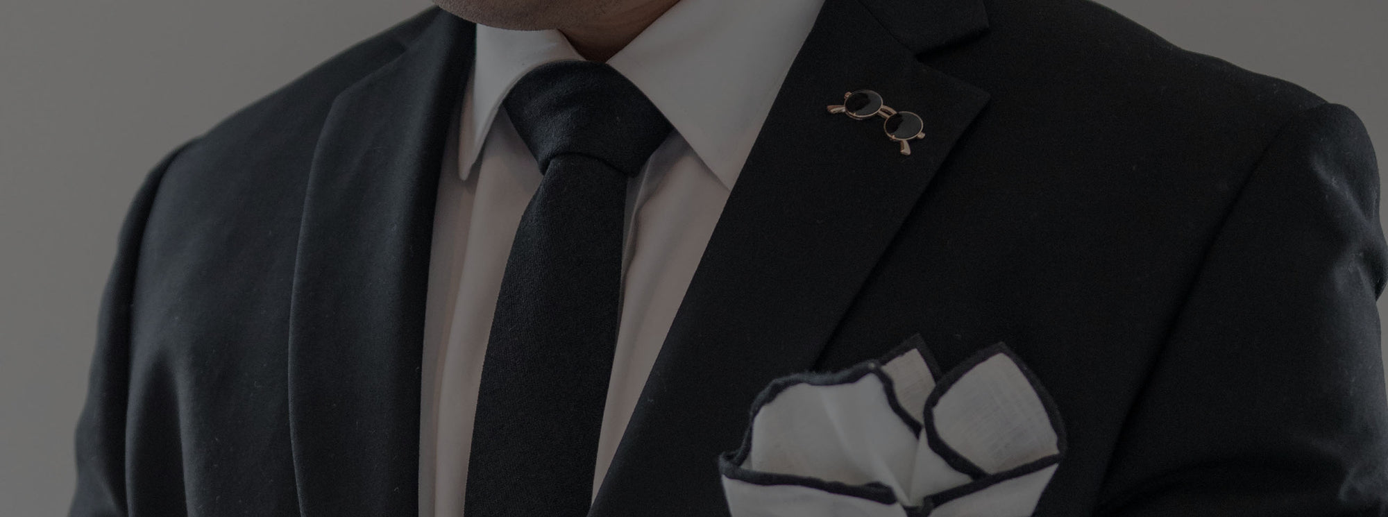 Black suit with an enamel lapel pin
