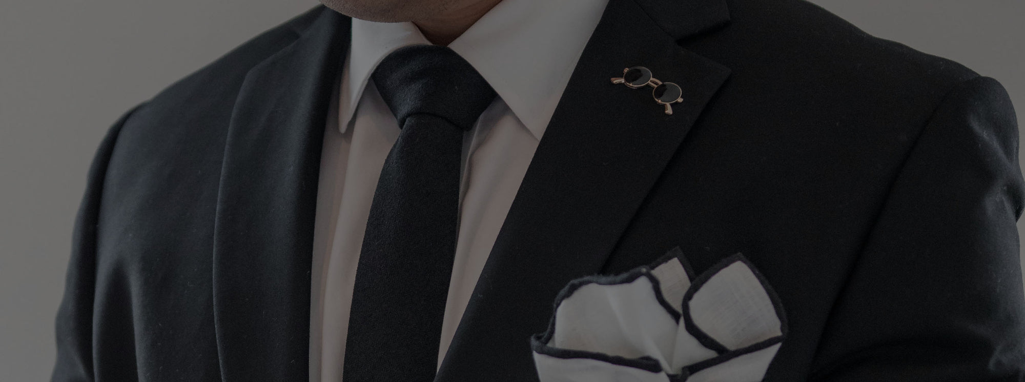 charcoal grey suit with enamel lapel pin