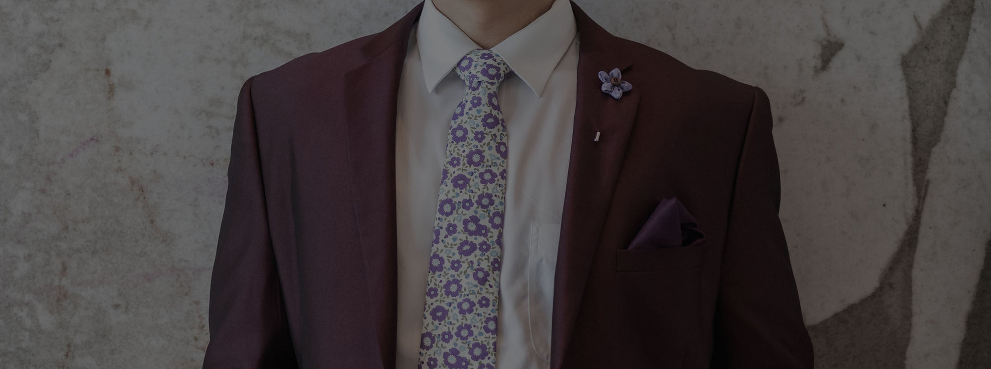 Man wearing burgundy suit and complementing lavender floral tie