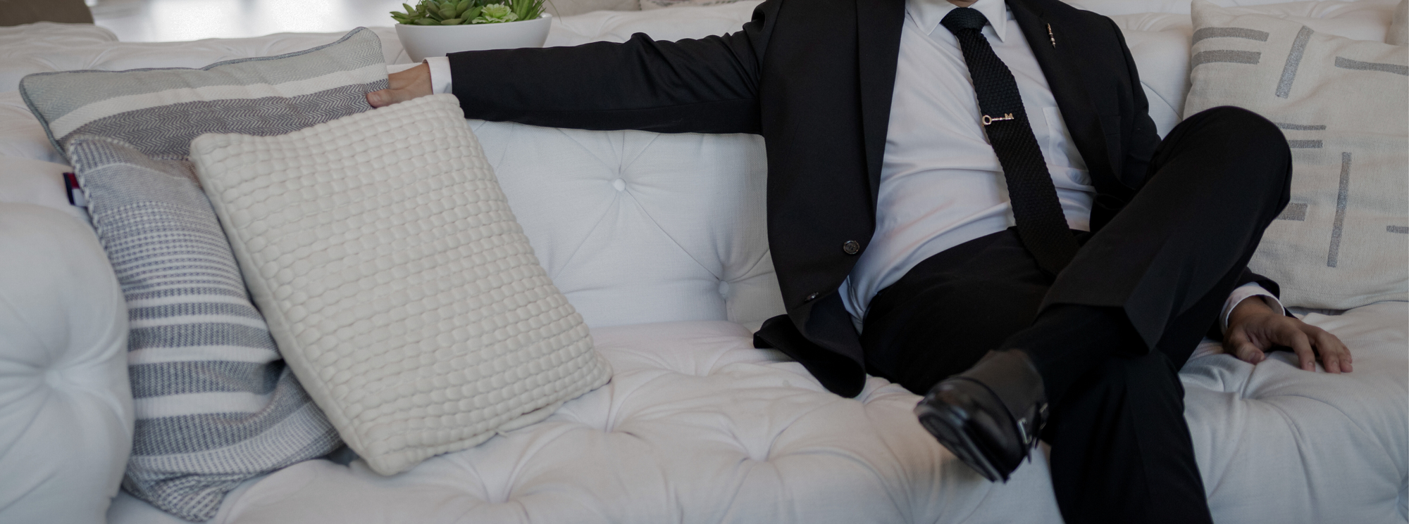 a gentleman sitting down in a black suit