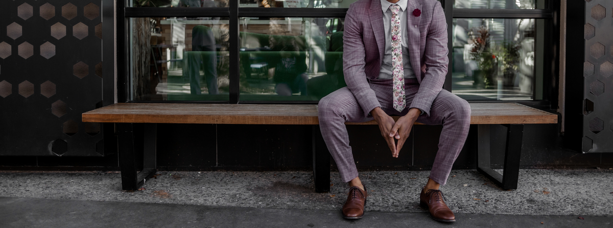 Man sitting on bench in a suit.