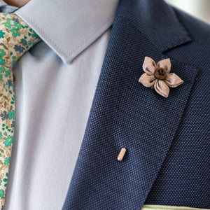 Wildflower Teak Lapel pin on a navy colored suit lapel