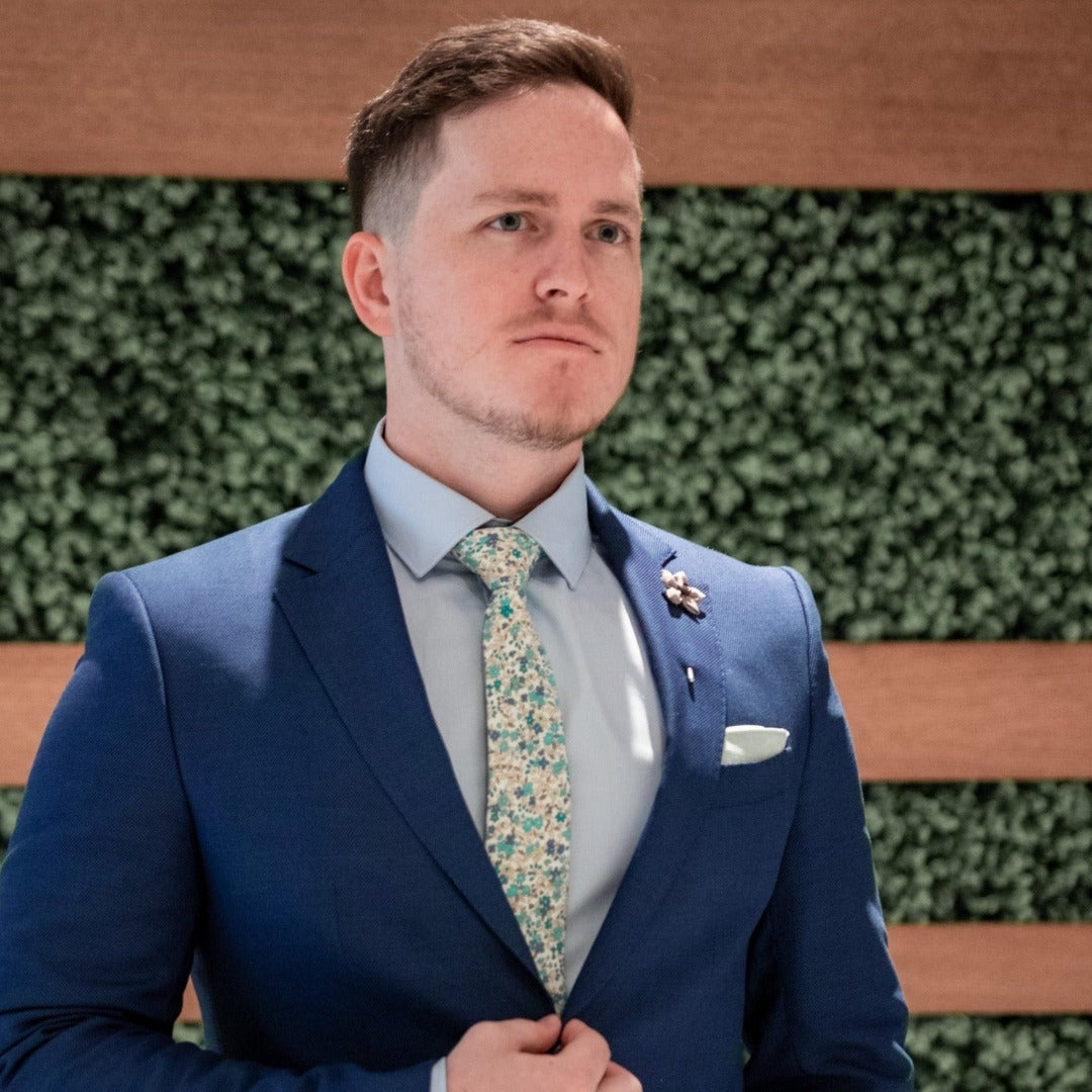 Floral Wildflower Teak Lapel Pin over navy suit