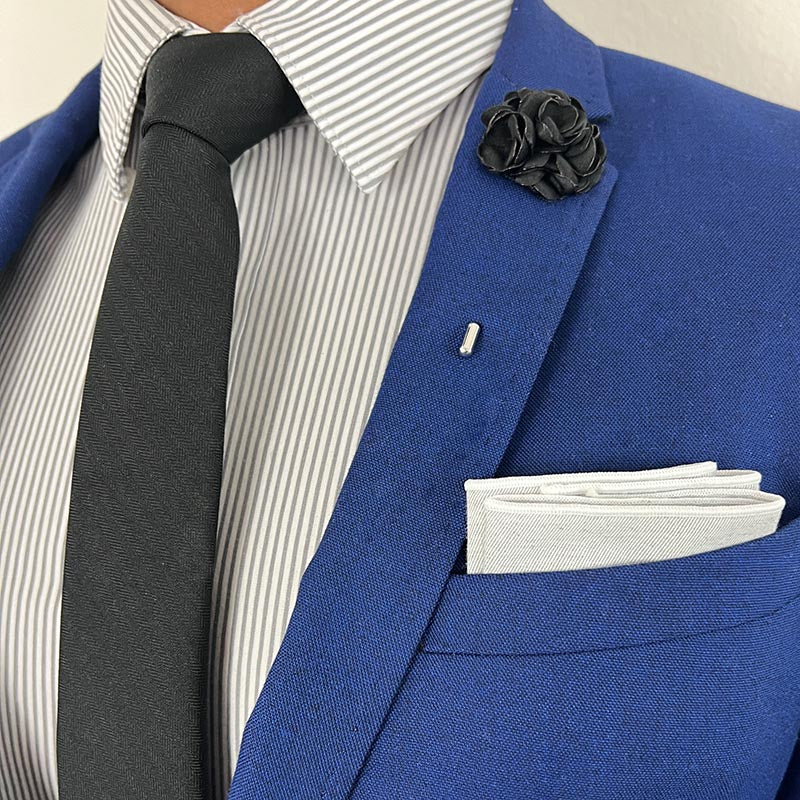 Black Herringbone Tie with a Black Rose Lapel Pin with a blue suit