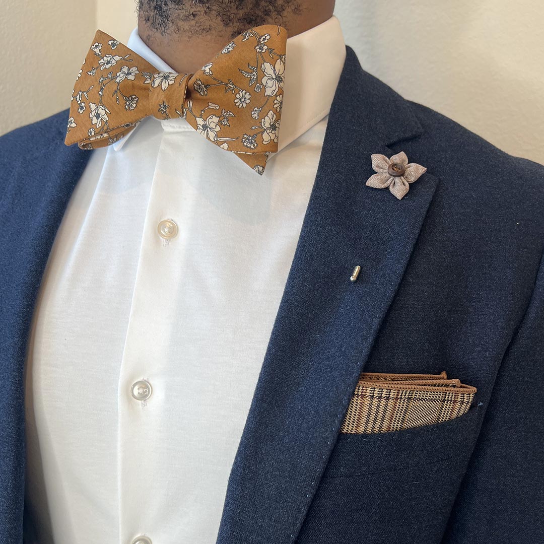 Man wearing navy suit with Floral Brown Bow Tie Set