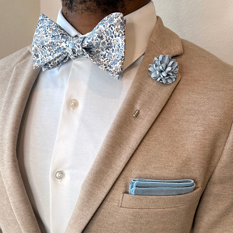 Man wearing Tan Suit with Floral Blue Mist Bow Tie Set and a white shirt