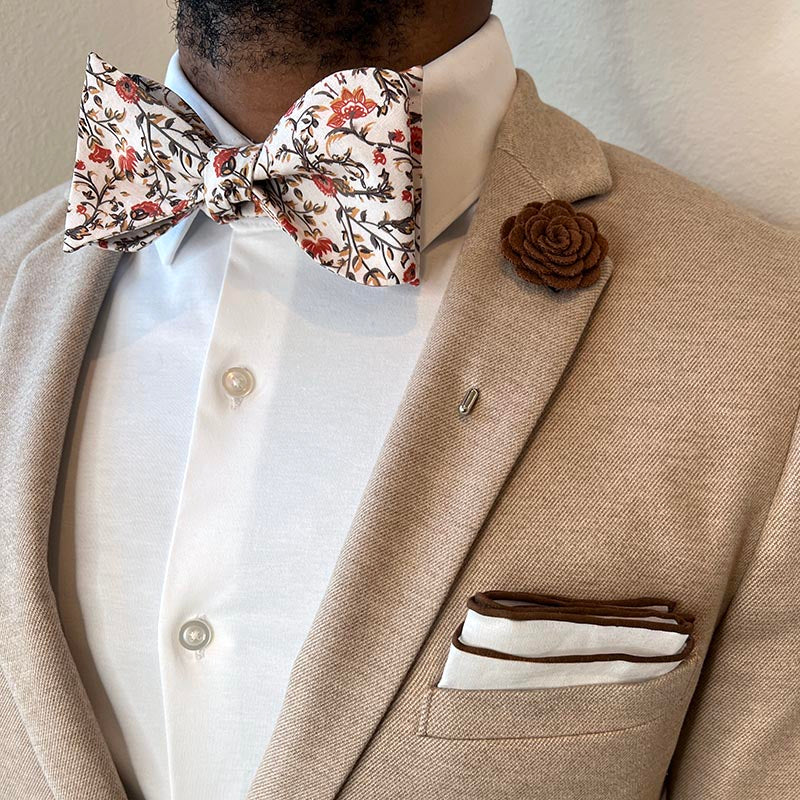 Man wearing tan suit with Floral Rust Blooms Bow Tie Set and a white shirt