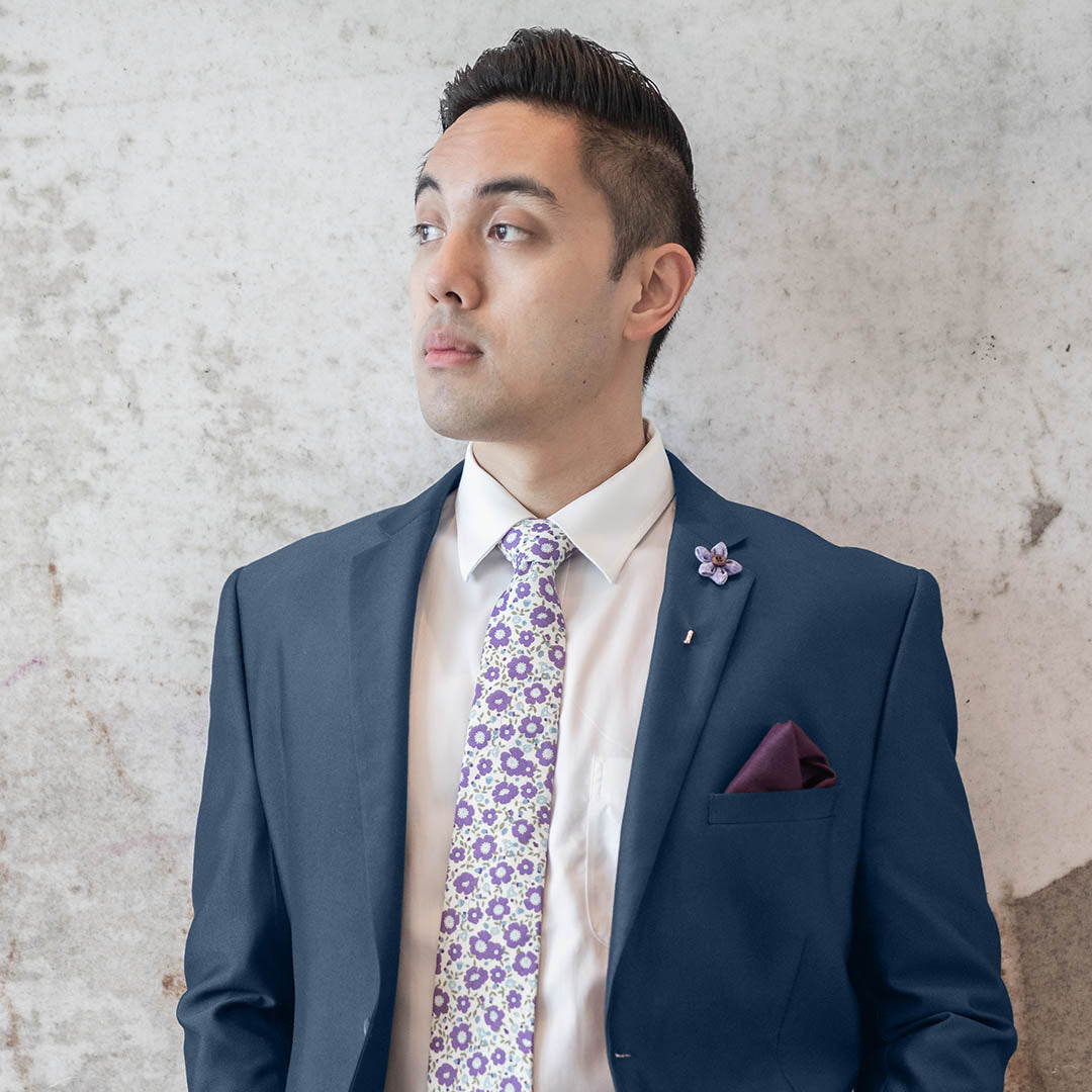 Wildflower lilac lapel pin on a burgundy suit lapel