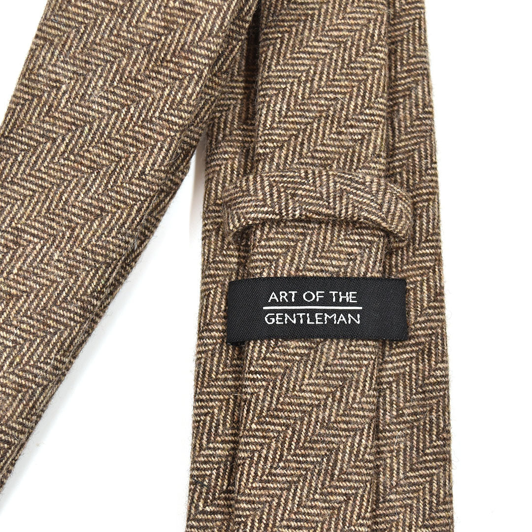 Brown herringbone tie with a label on a white background