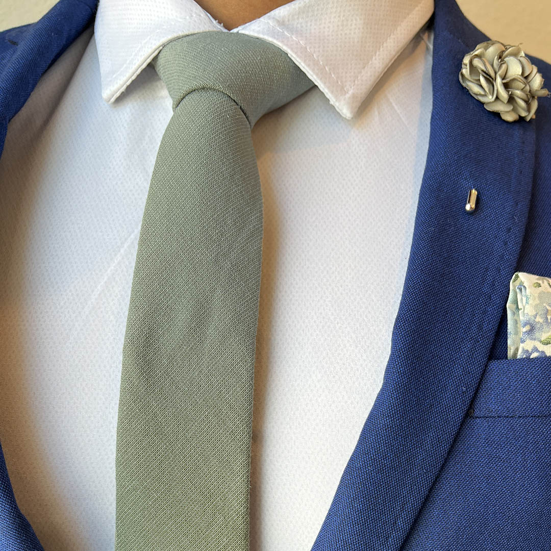 Kids pre tied linen sage green tie with a blue suit