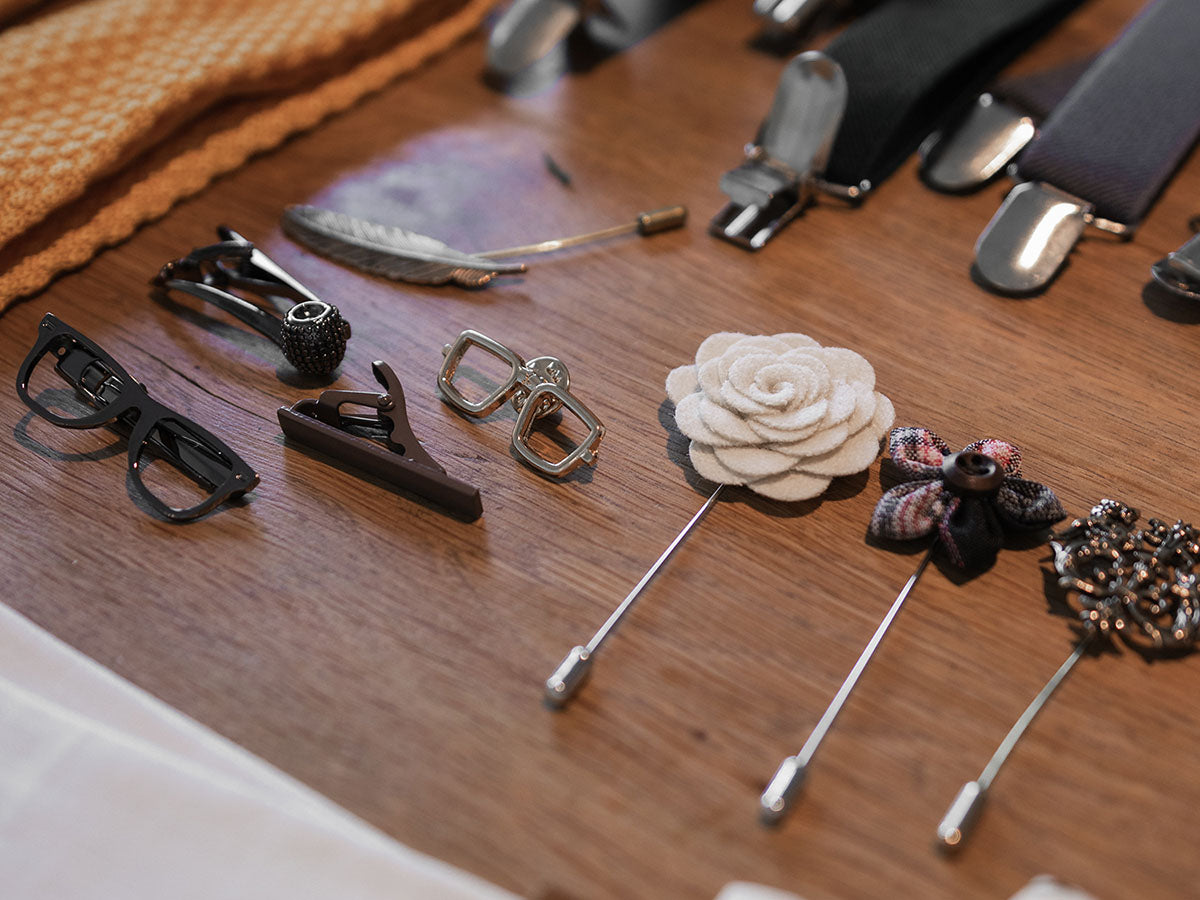 Collection of various lapel pins on a wooden surface