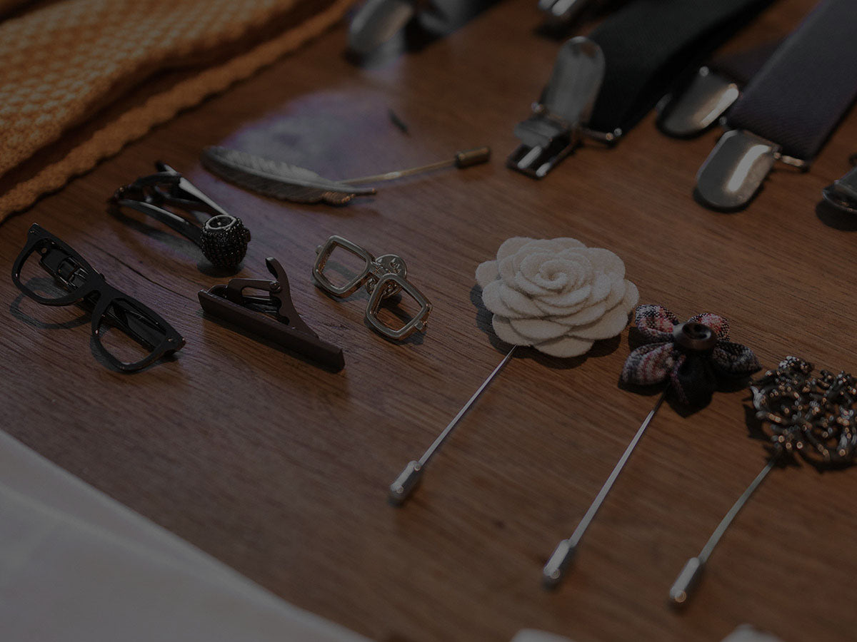 Collection of lapel pins and accessories on a wooden surface