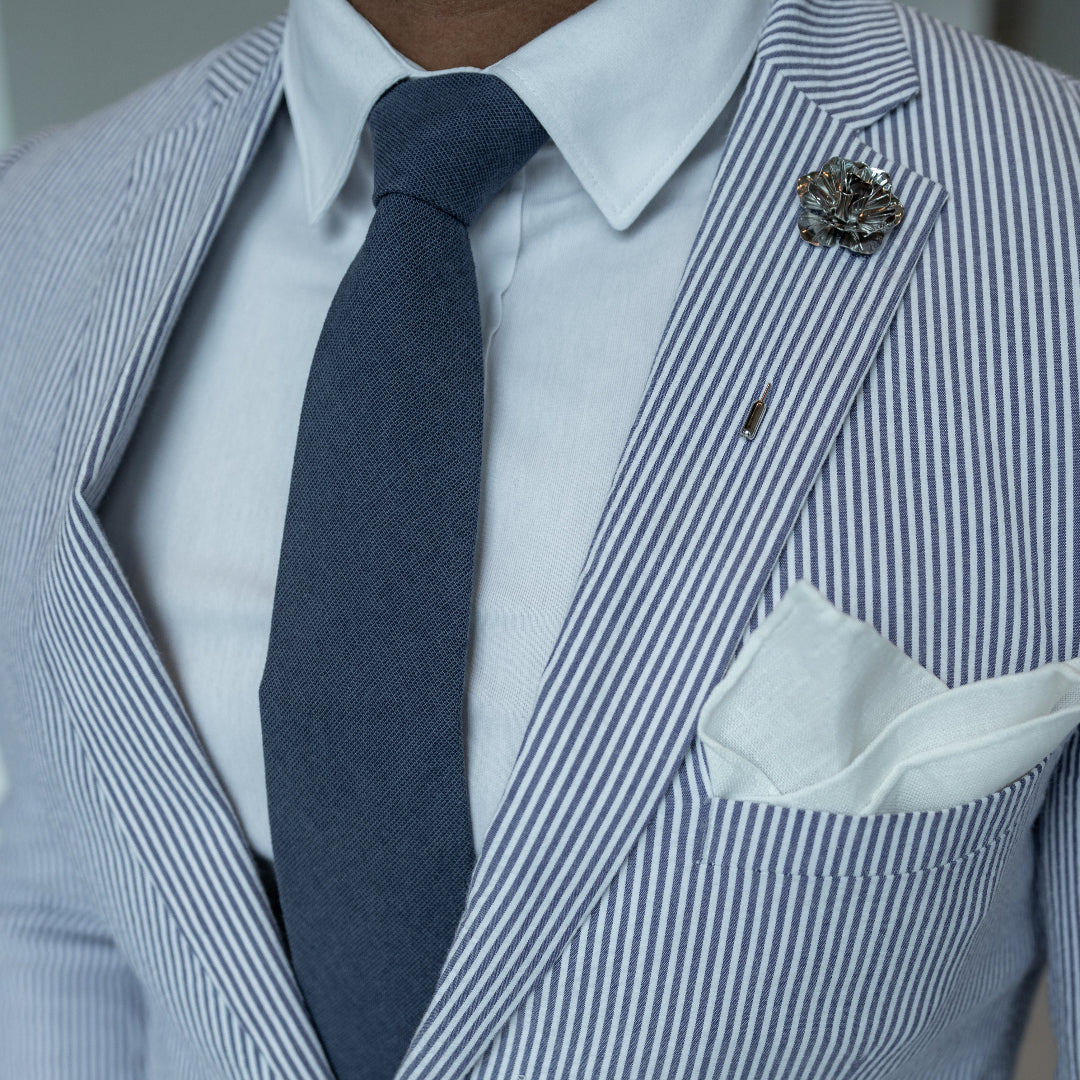 Kid wearing a solid navy marine pre tied kids bow tie with a seersucker suit for a summer wedding. 