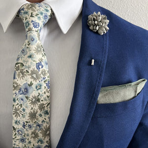 Gentleman wearing a floral blue and olive green tie with a Sage Green Lapel Pin