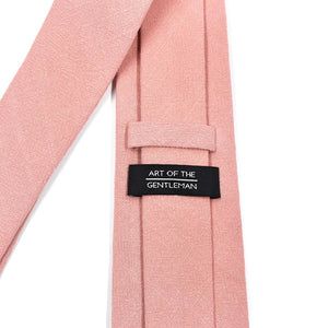 Pink tie with a label reading 'Art of the Gentleman' on a white background