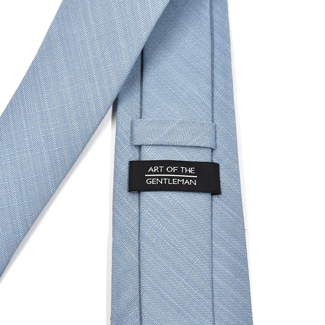 Light blue tie with 'Art of the Gentleman' label on a white background