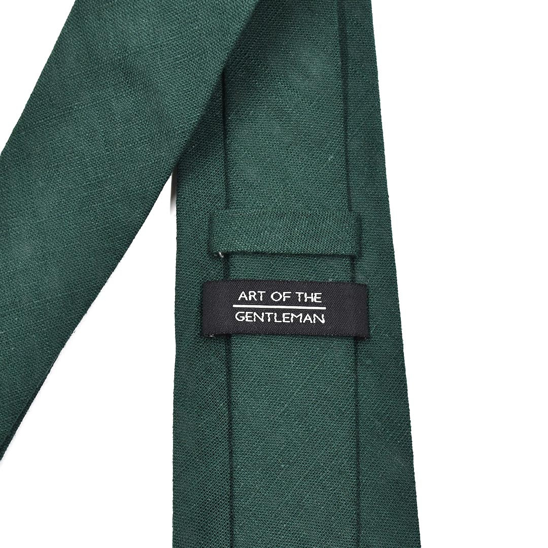 Green tie with 'Art of the Gentleman' label on a white background