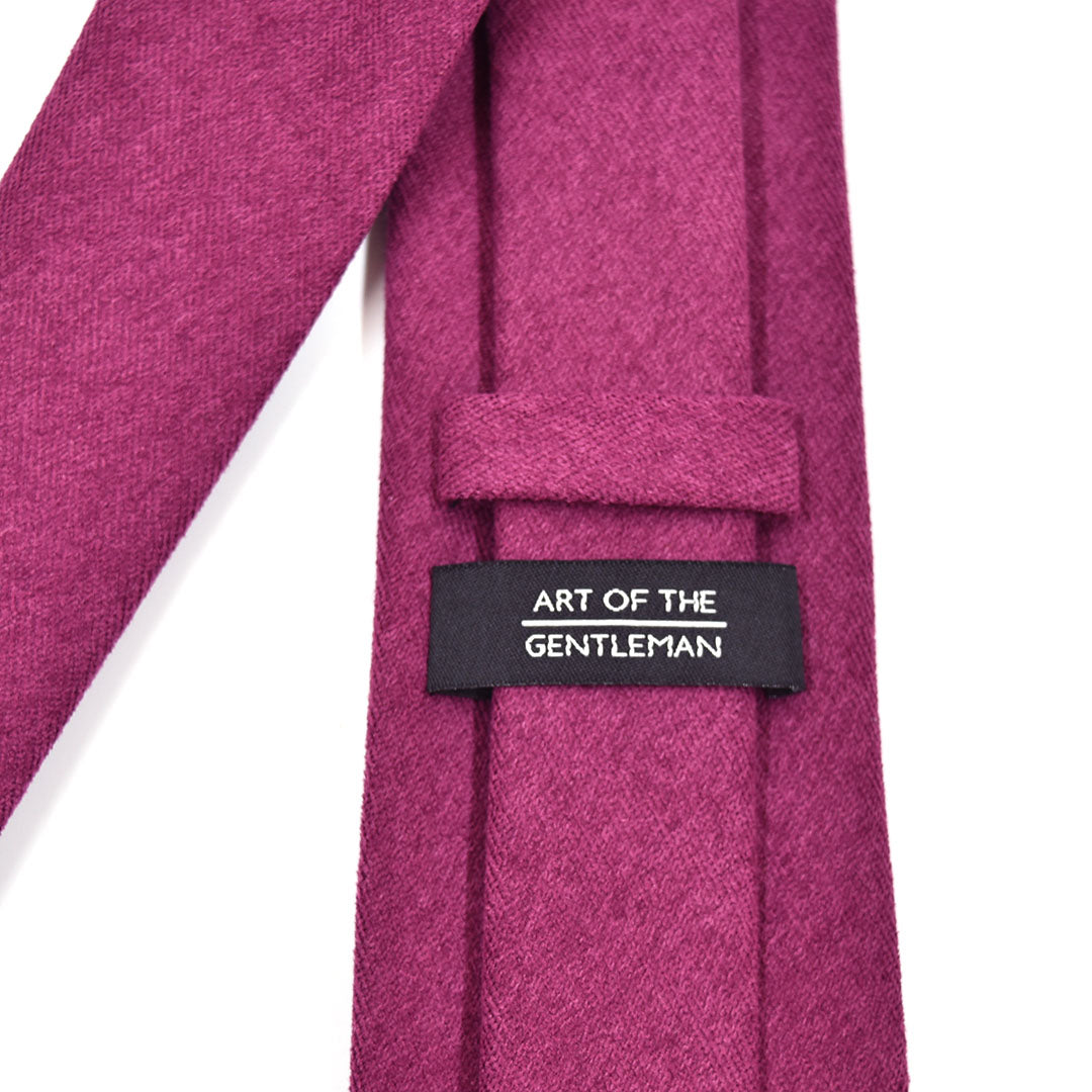 Close-up of a Mulberry tie with a label reading 'Art of the Gentleman' on a white background