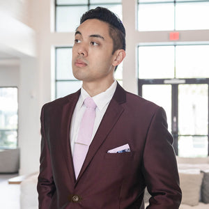 Silver pen tie bar on a lavender tie and burgundy suit