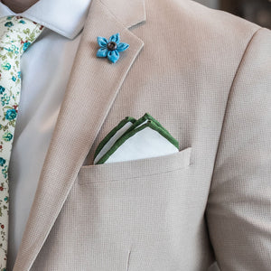 Olive border linen pocket square with a tan suit paired with a floral tie