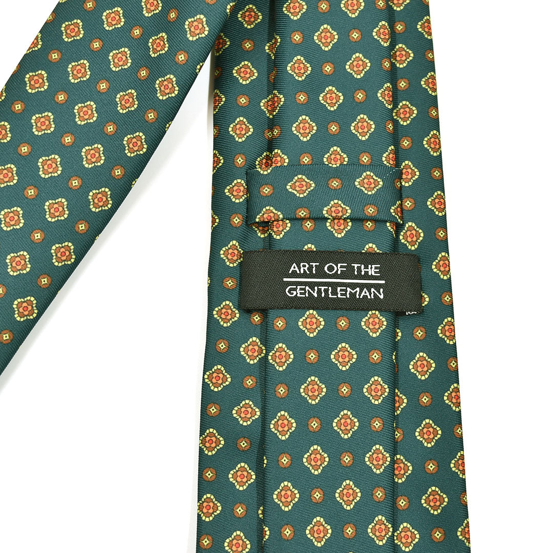 Patterned green and orange tie with 'Art of the Gentleman' label on a white background
