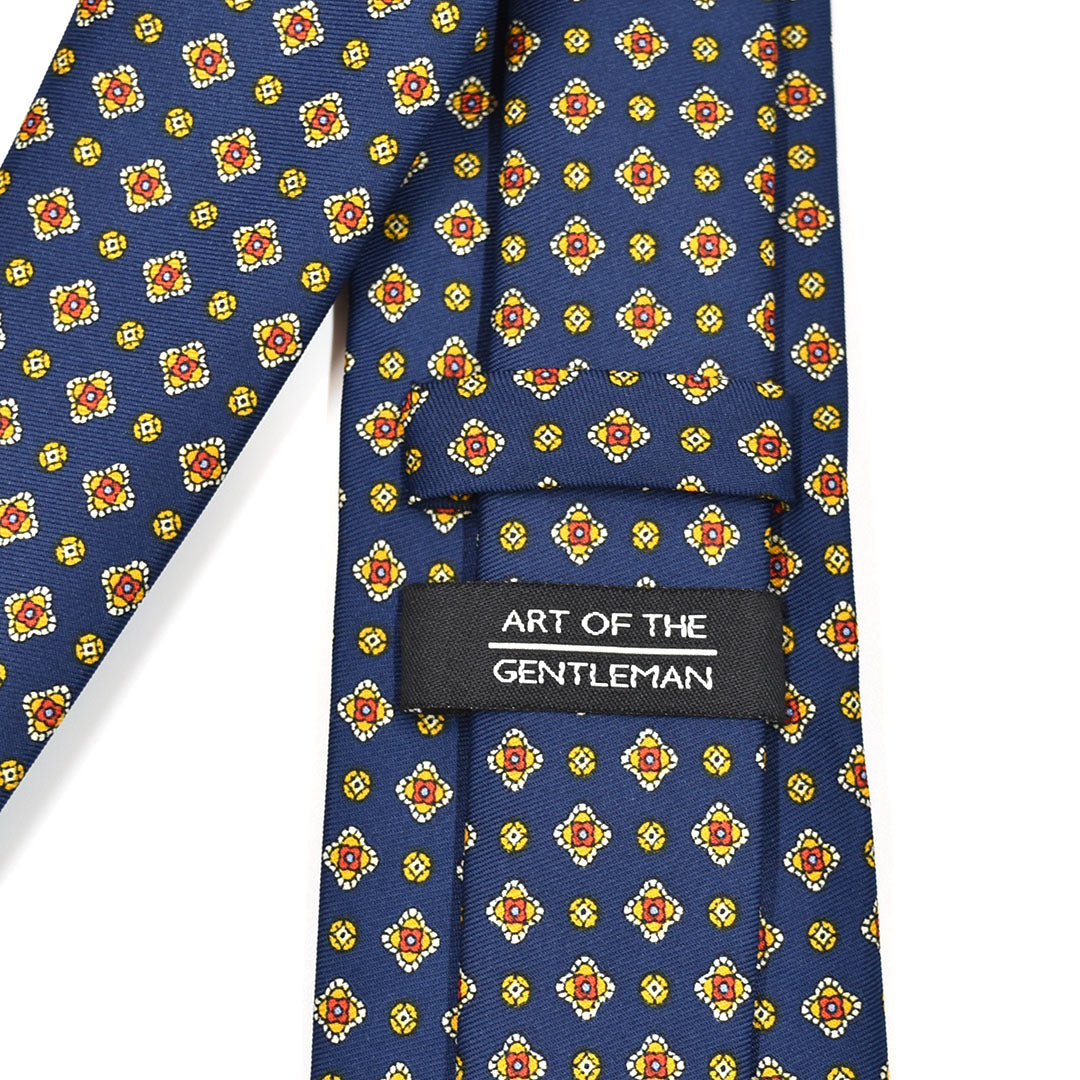 Navy blue tie with colorful geometric pattern and 'Art of the Gentleman' label.