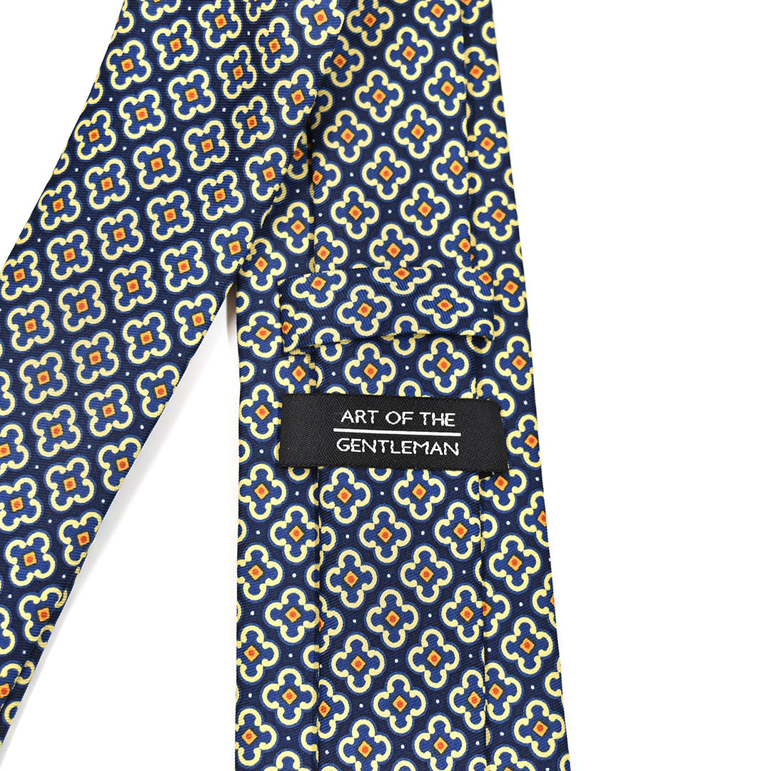 Navy blue tie with floral pattern and 'Art of the Gentleman' label on a white background