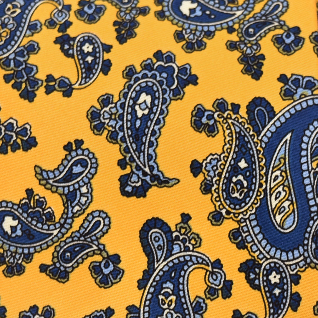 Navy paisley pattern on a yellow fabric background