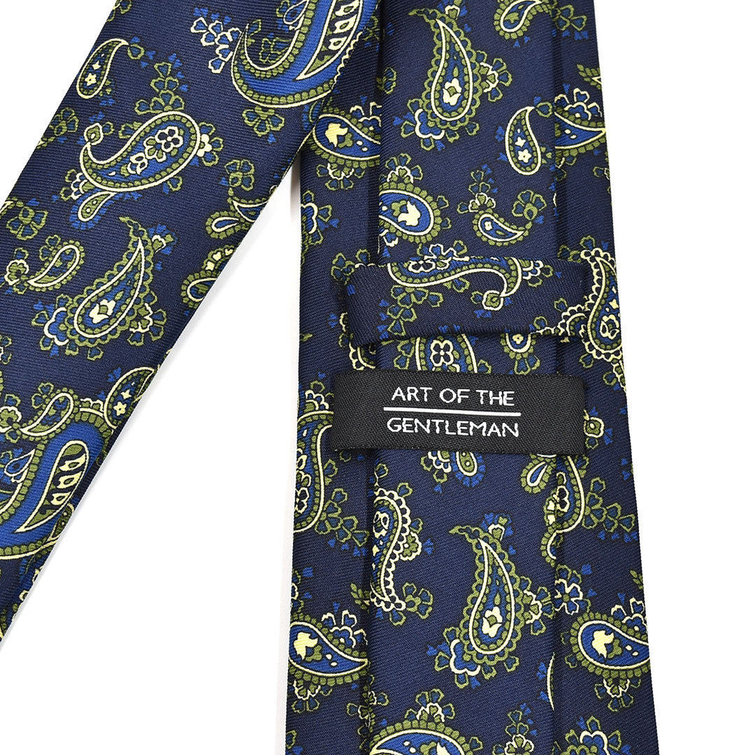 Navy blue tie with green paisley pattern and 'Art of the Gentleman' label on a white background