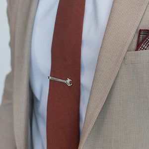 Silver Wrench Tie Clip over a cinnamon colored tie with a tan suit