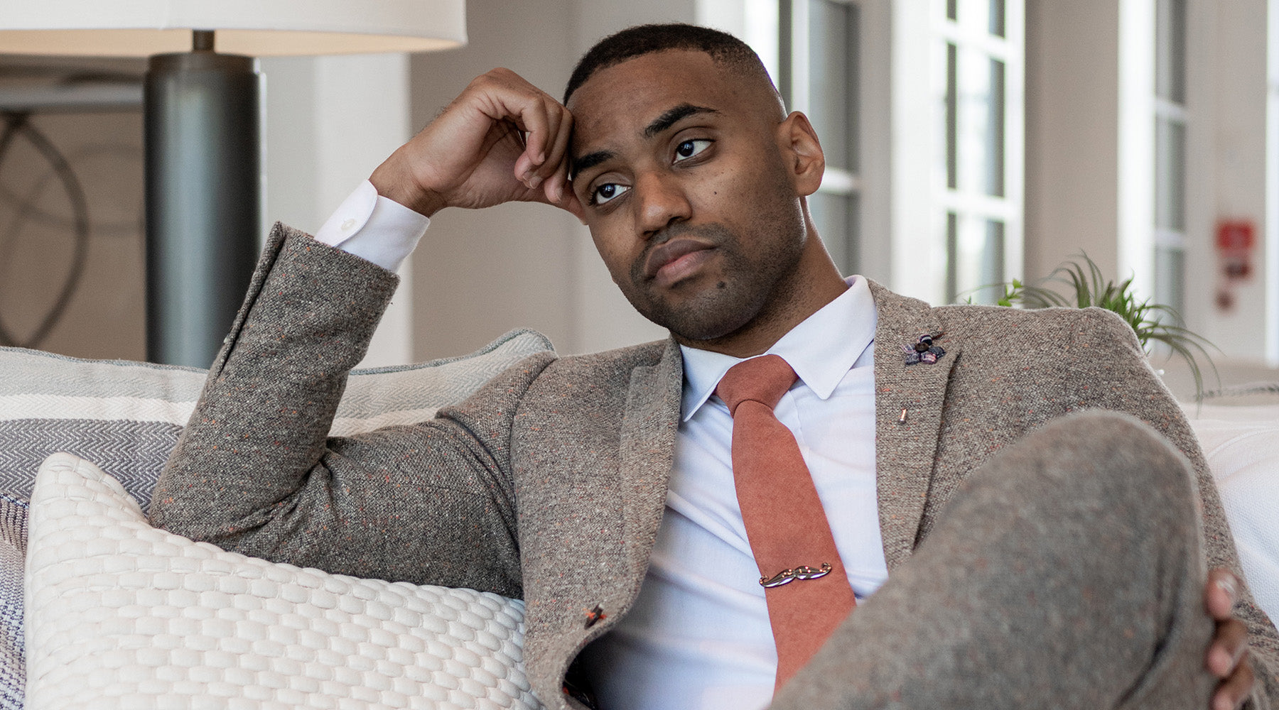 Art of The Gentleman wearing a suit and tie sitting on a couch